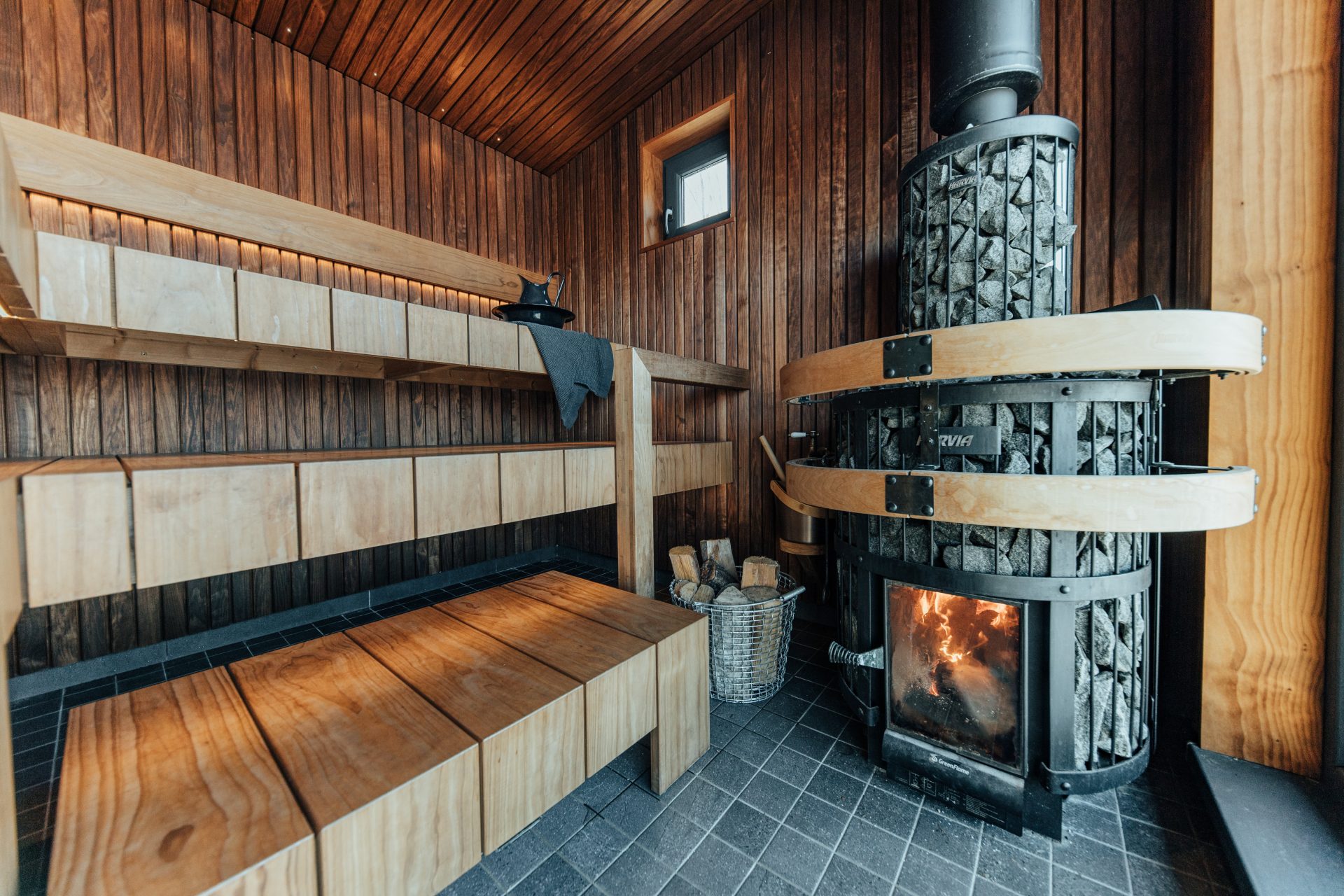 Āra saunas dizains ar klasisku pirts apdari un modernu lāvu